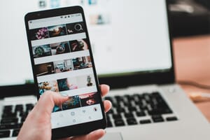 A cell phone displaying a social media Instagram feed.