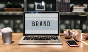 A laptop screen displaying the word "Brand."